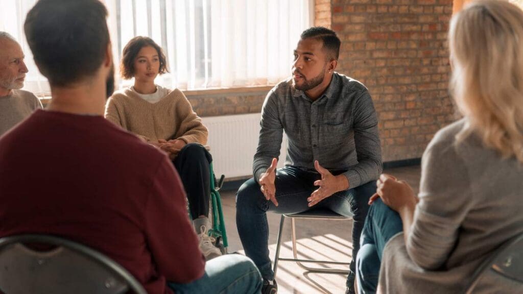 Patient sharing personal experiences during group therapy at outpatient drug rehab.