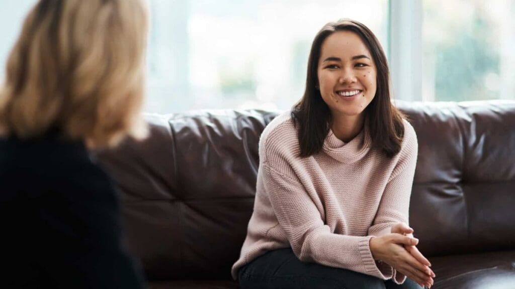 Therapist talking to young client about holistic mental health treatment.