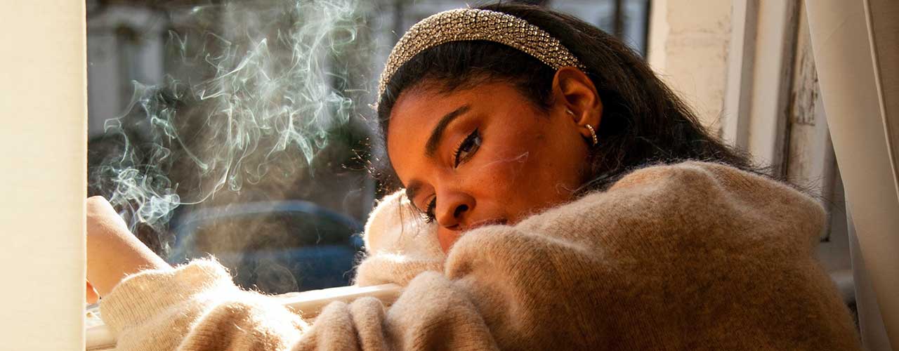 woman smoking out of her window