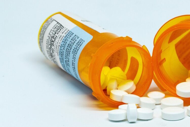 Percocet and hydrocodone pills pouring from bottles