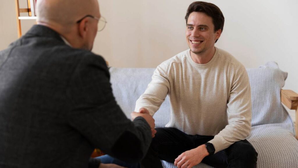 Male patient talking to therapist during outpatient drug rehab.