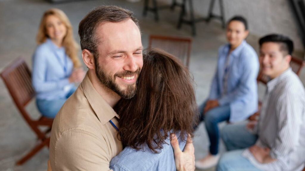 A therapist supporting his client during group therapy at rehab in Johnson City, TN.