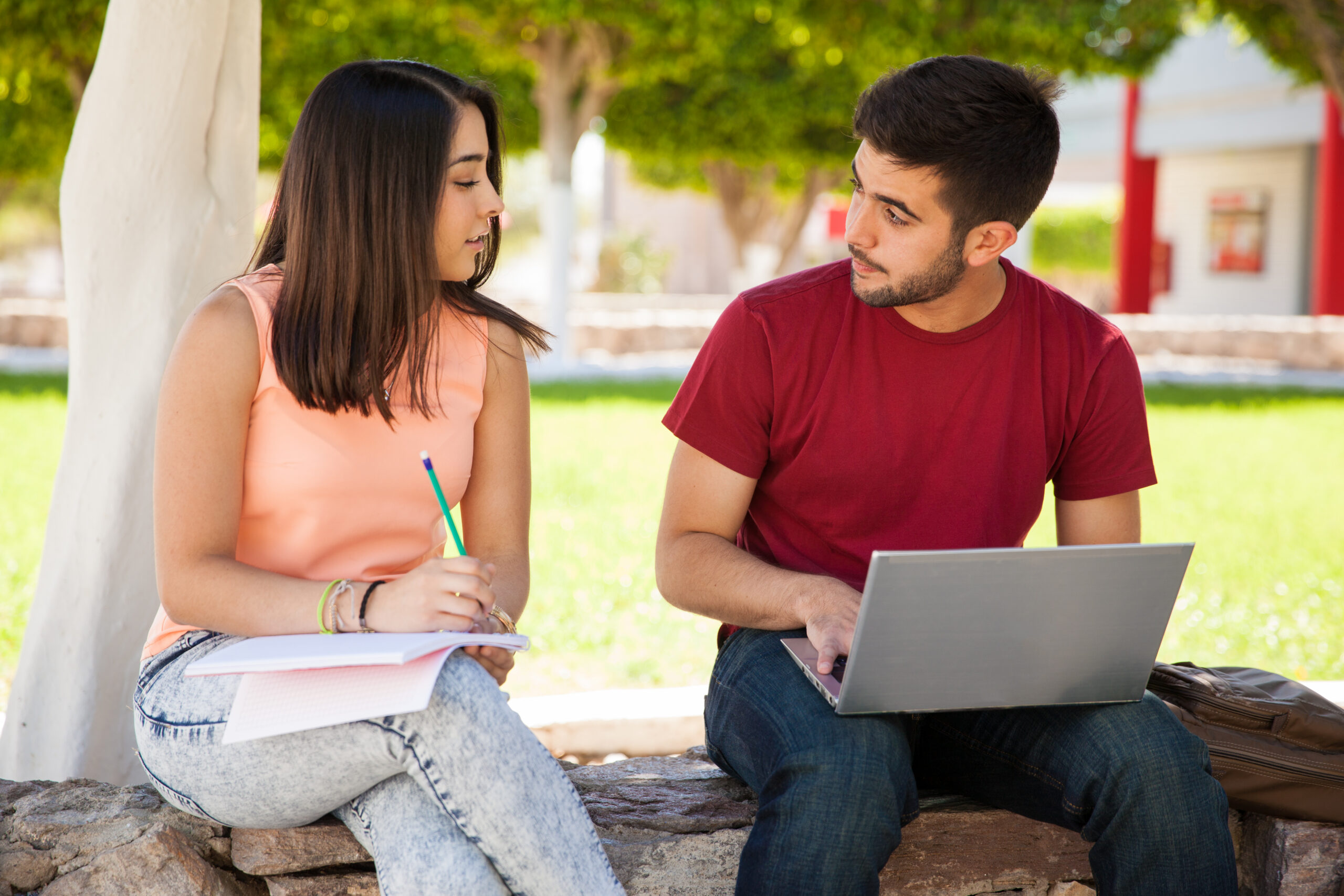 Latinx college students talking together on campus while studying